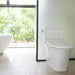 Modern white toilet with Brondell Swash Thinline T22 electric bidet installed in a bright bathroom with a window view of greenery.